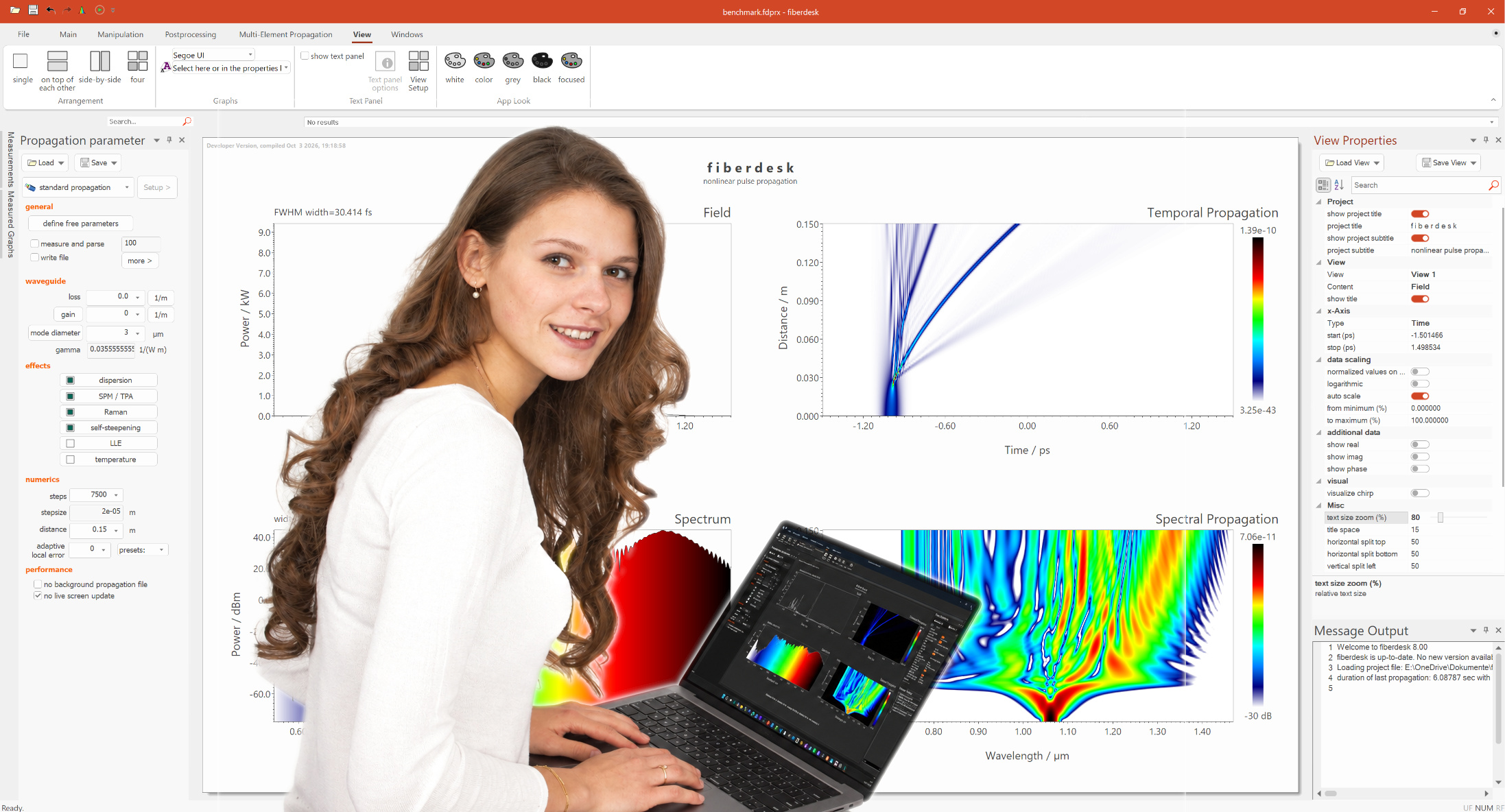 fiberdesk showing nonlinear pulse propagation results, with a user working on a laptop
